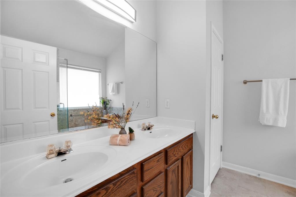281 Hutton Kyle, TX 78640 - Photo 26 of 37 Double vanity sinks and a bright window elevate daily routines in this primary bathroom.