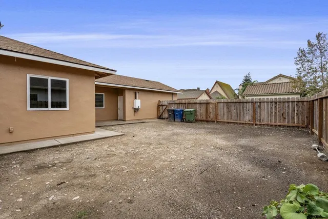 a view of a house with a yard and fence