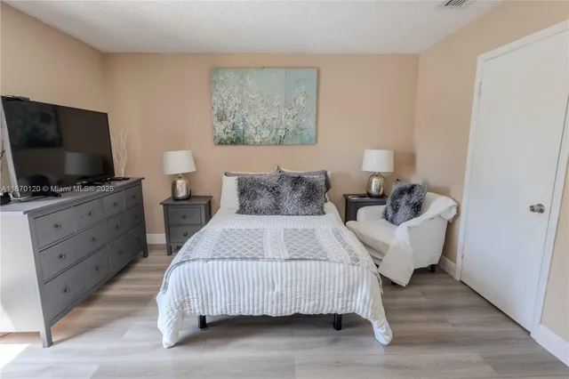 a bedroom with a bed and a flat screen tv