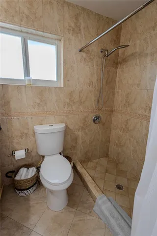 a bathroom with a toilet and a shower