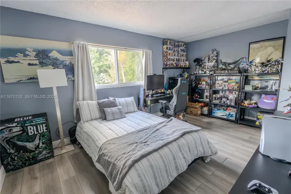 a bedroom with bed a dresser and a window