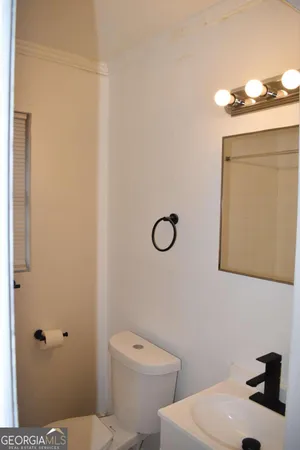 a bathroom with a sink a toilet and mirror