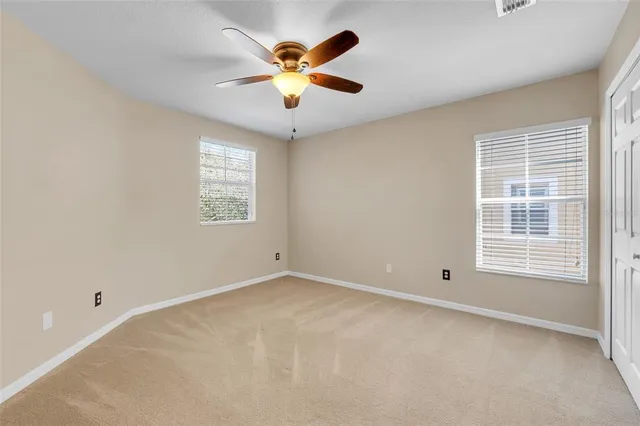 a view of an empty room with a ceiling fan