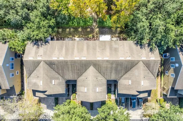 an aerial view of a house with a yard and trees all around