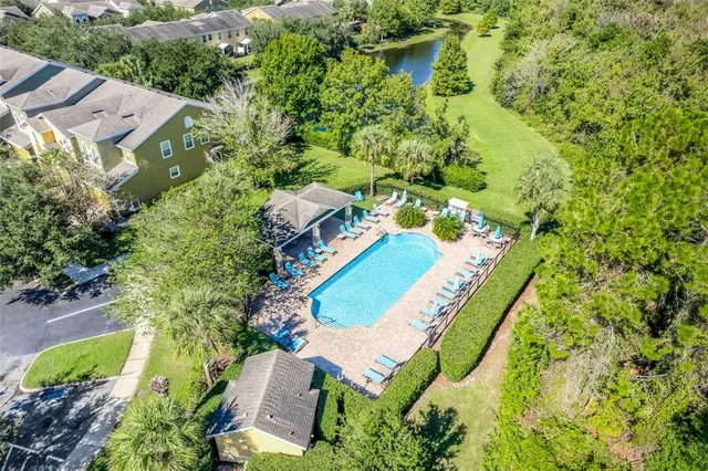 a view of a swimming pool with a patio and a yard