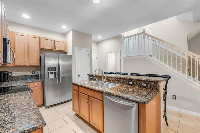 a kitchen with stainless steel appliances granite countertop a sink stove and refrigerator