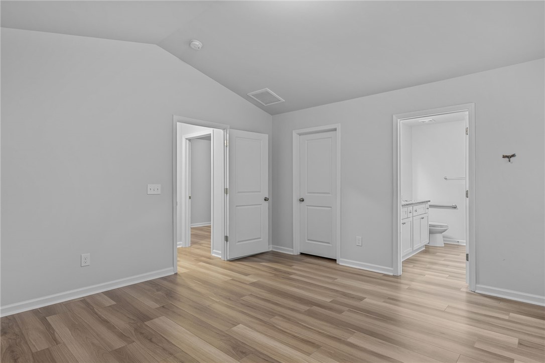 24 Chalet Court Anderson, SC 29621 - Photo 17 of 39 Bright and airy bedroom with sleek flooring, offering convenient access to an adjoining bathroom.