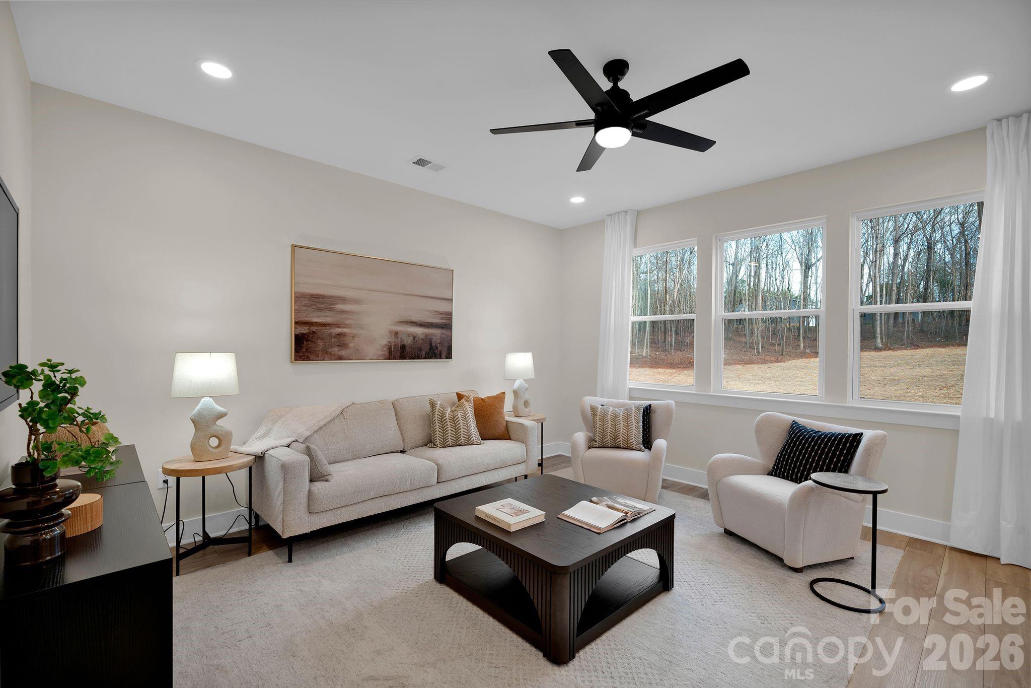 9022 Unity Church Road Mooresville, NC 28115 - Photo 3 of 22 a living room with furniture a ceiling fan and a large window