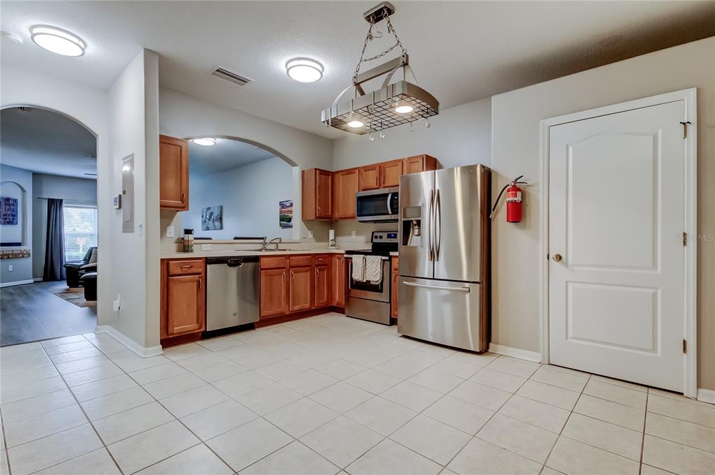 1138 Hillhurst Drive Wesley Chapel, FL 33543 - Photo 22 of 65 a kitchen with stainless steel appliances granite countertop a refrigerator a sink dishwasher and a stove with wooden floor