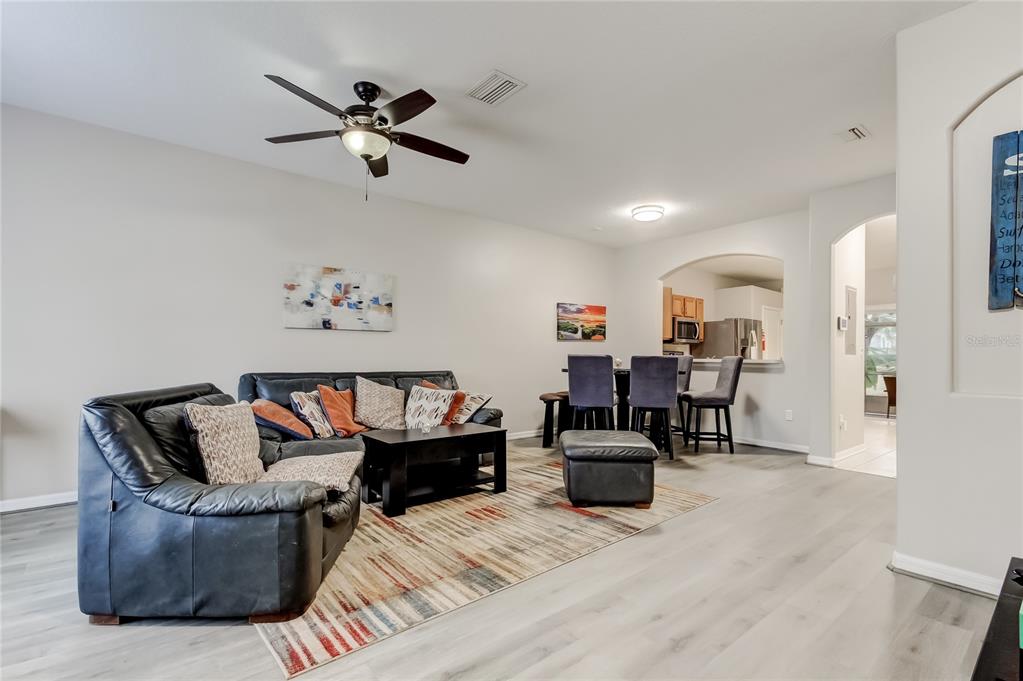 1138 Hillhurst Drive Wesley Chapel, FL 33543 - Photo 4 of 65 a living room with furniture and a chandelier