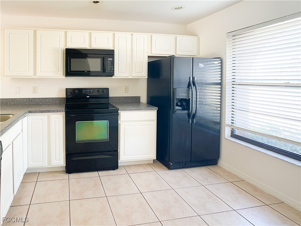 1156 Southwest 47th Terrace Cape Coral, FL 33914 - Photo 2 of 13 a kitchen with granite countertop a refrigerator and a stove top oven