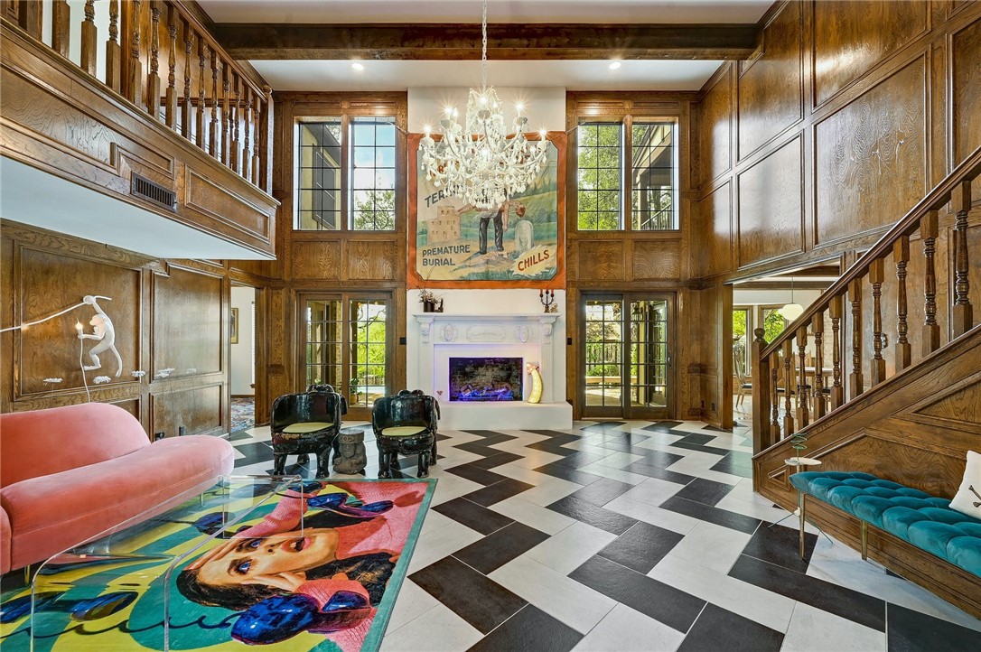 a living room with furniture a fireplace and a chandelier