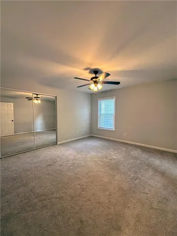 a view of an empty room with a chandelier fan