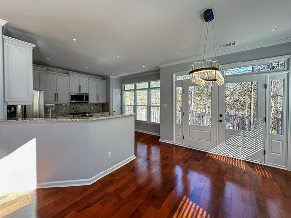 a kitchen with stainless steel appliances granite countertop a refrigerator a stove top oven and a wooden floors