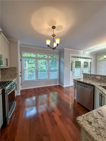 a kitchen with granite countertop wooden floors and stainless steel appliances