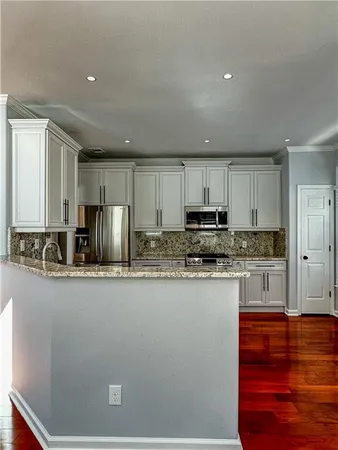 a kitchen with stainless steel appliances granite countertop a stove a sink and a refrigerator