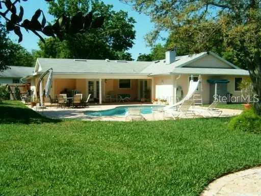 a front view of the house with yard patio and green space