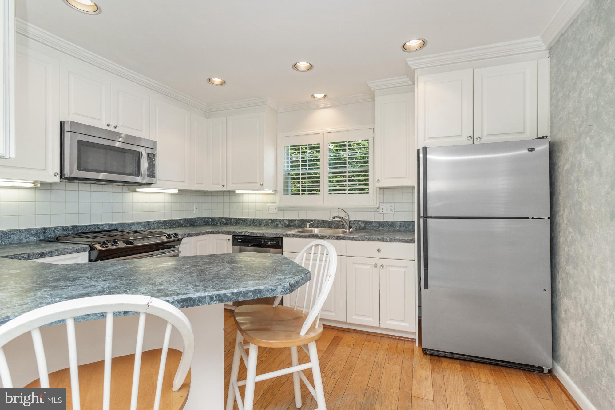 1429 Adamsview Road Baltimore, MD 21228 - Photo 11 of 44 a kitchen with granite countertop a refrigerator stove top oven and sink