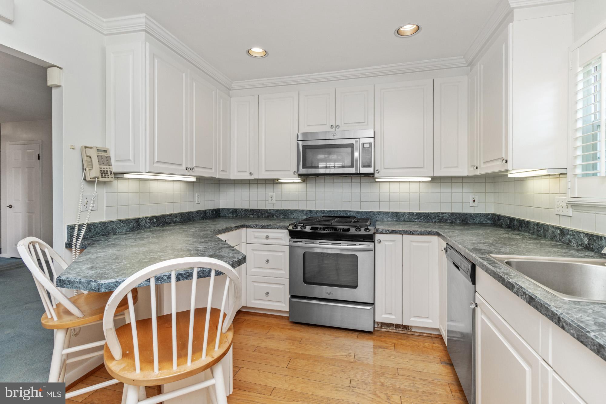 1429 Adamsview Road Baltimore, MD 21228 - Photo 12 of 44 a kitchen with stainless steel appliances granite countertop a stove a sink and a microwave