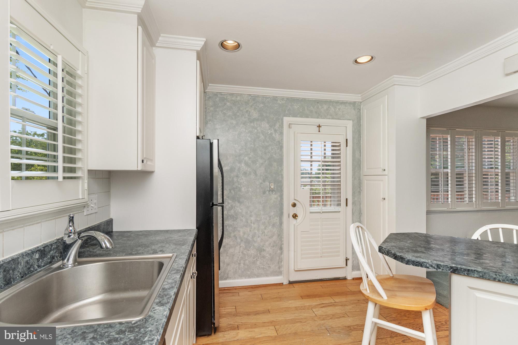 1429 Adamsview Road Baltimore, MD 21228 - Photo 14 of 44 a kitchen with granite countertop a sink and a refrigerator
