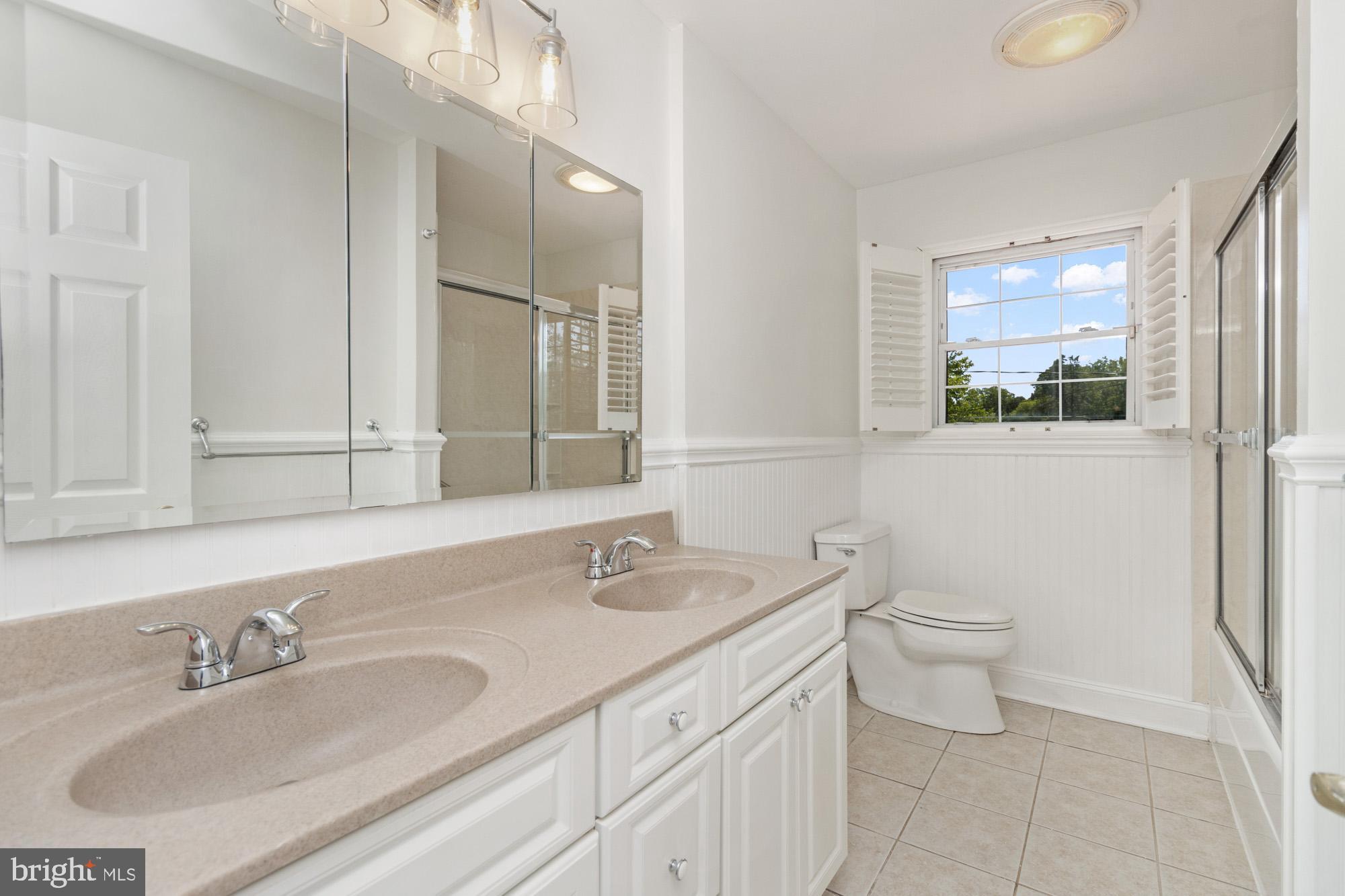 1429 Adamsview Road Baltimore, MD 21228 - Photo 16 of 44 a bathroom with a granite countertop toilet sink and mirror