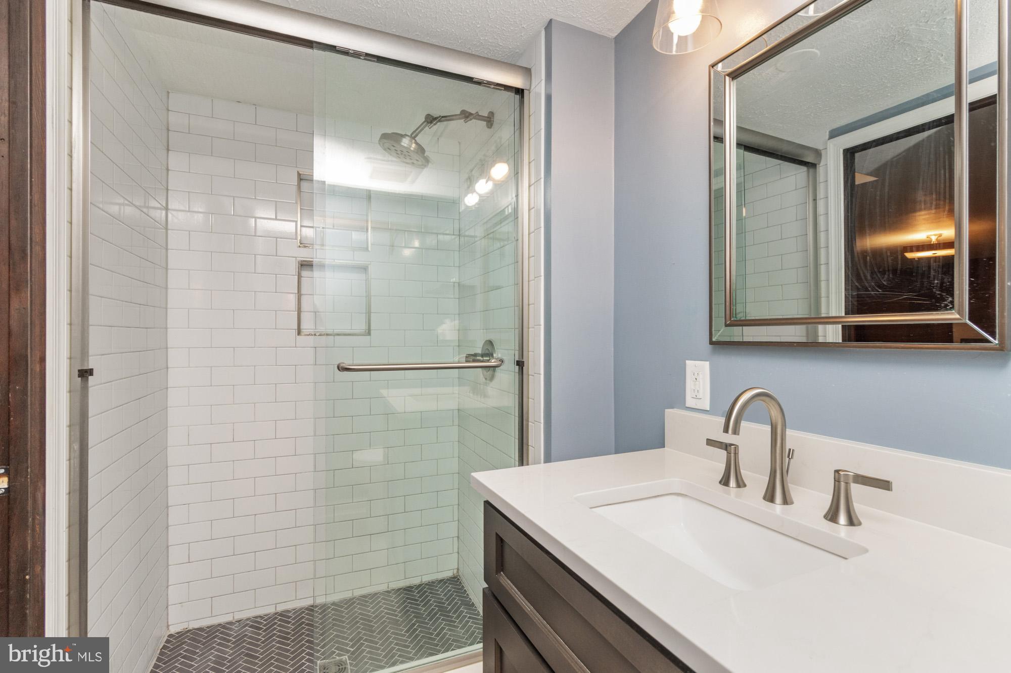 1429 Adamsview Road Baltimore, MD 21228 - Photo 30 of 44 a bathroom with a sink shower and a mirror