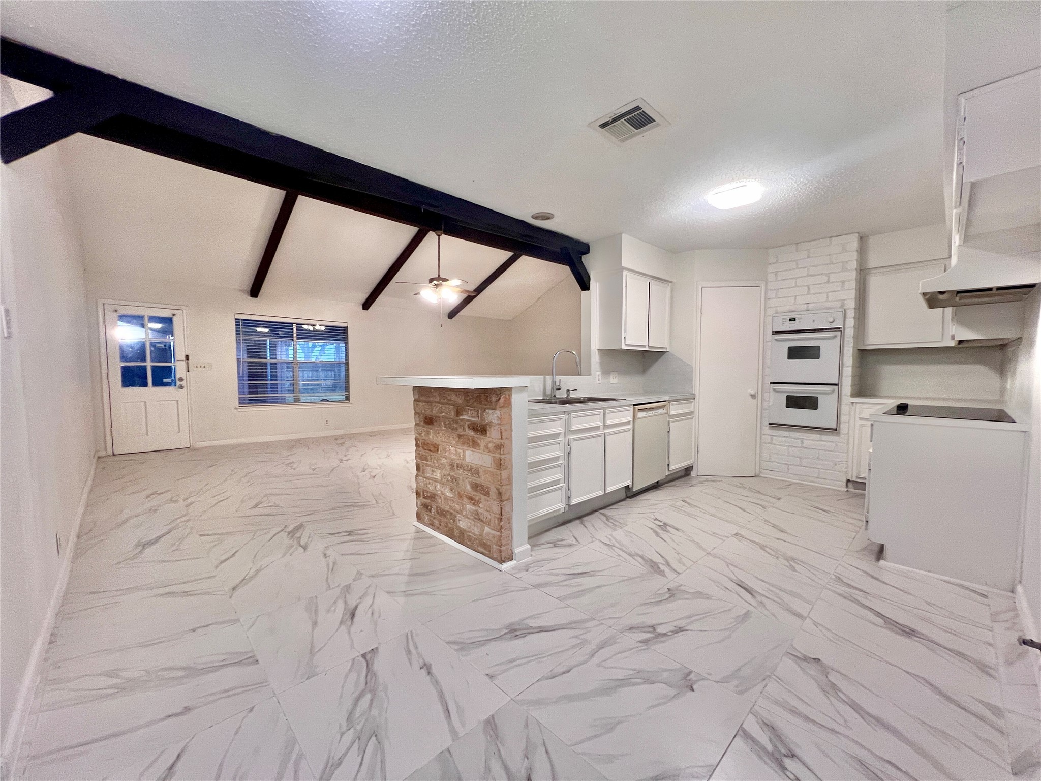 a large kitchen with stainless steel appliances cabinets and a large window