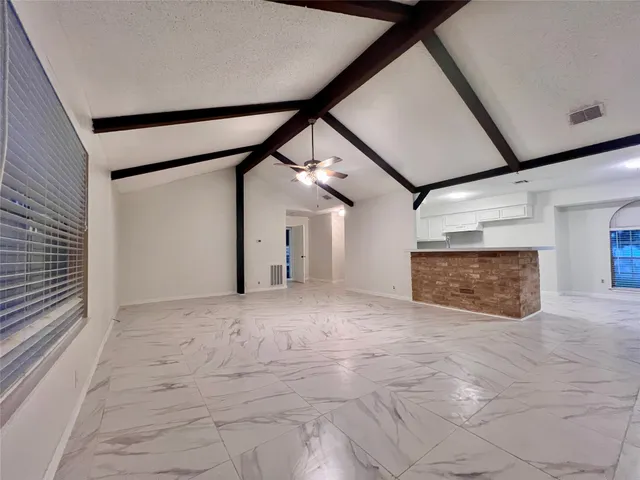 a view of empty room with floor to ceiling window and fireplace