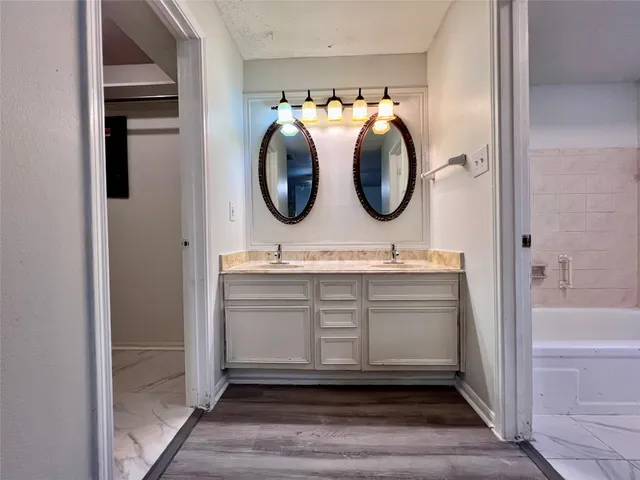 a bathroom with a granite countertop toilet sink and mirror