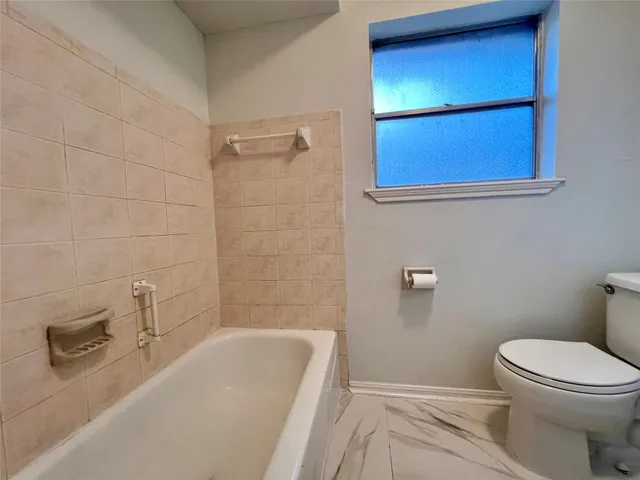 a bathroom with a toilet and a bathtub