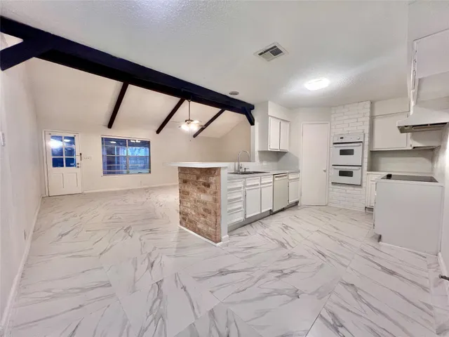 a large kitchen with stainless steel appliances cabinets and a large window