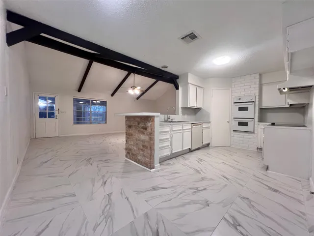 a large room with stainless steel appliances kitchen island granite countertop a stove a sink and a refrigerator