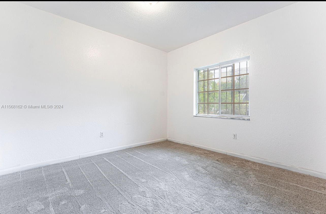 2320 Northwest 52nd Street, Unit A Miami, FL 33142 - Photo 8 of 8 an empty room with windows