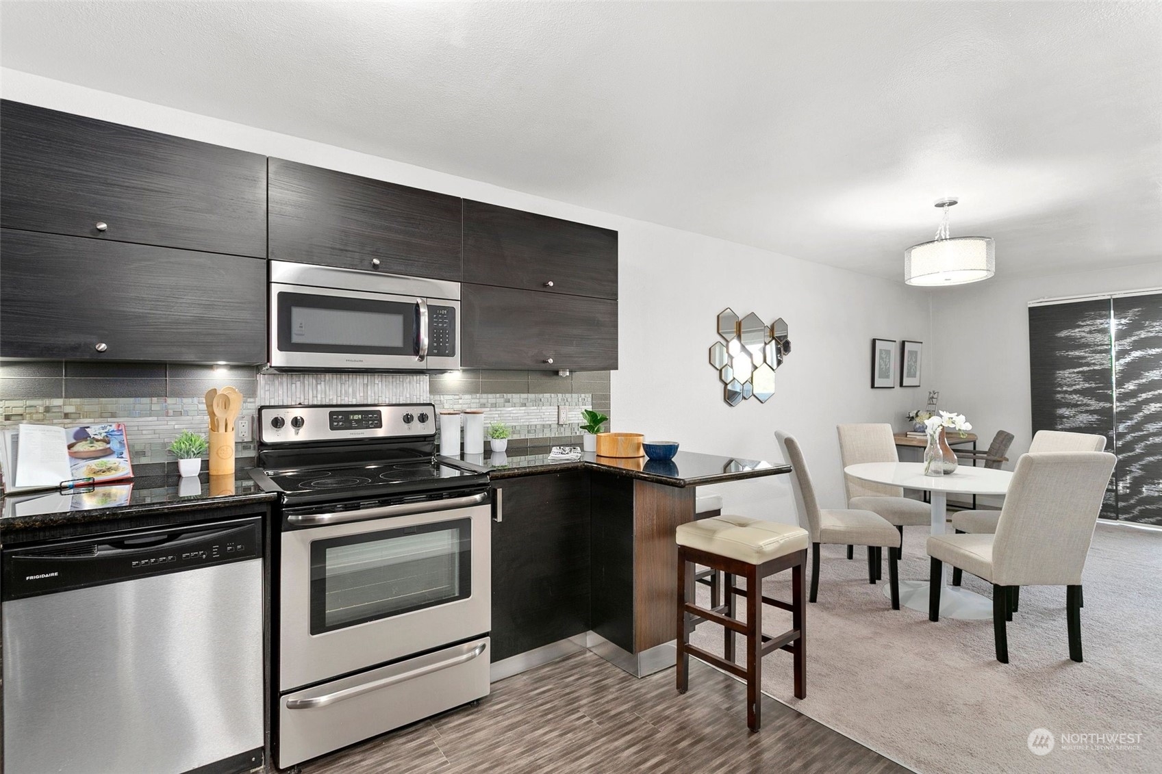 1425 South Puget Drive, Unit 308 Renton, WA 98055 - Photo 6 of 23 a kitchen with a stove a sink and chairs