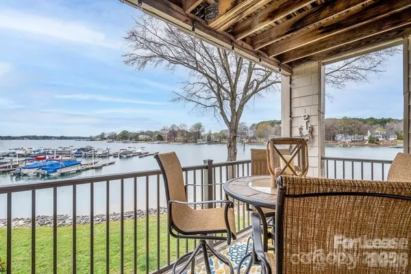 a view of a balcony with wooden floor and outdoor seating