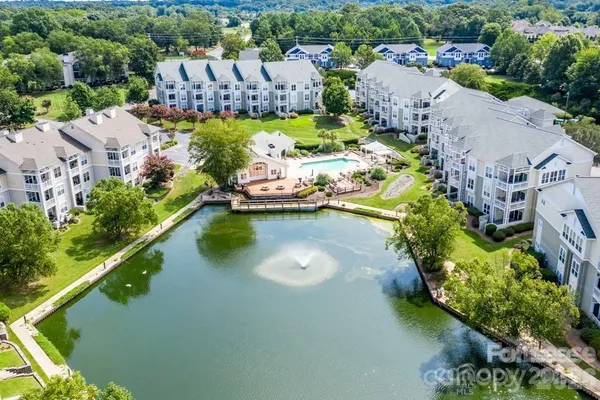 an aerial view of a house with a garden and lake view