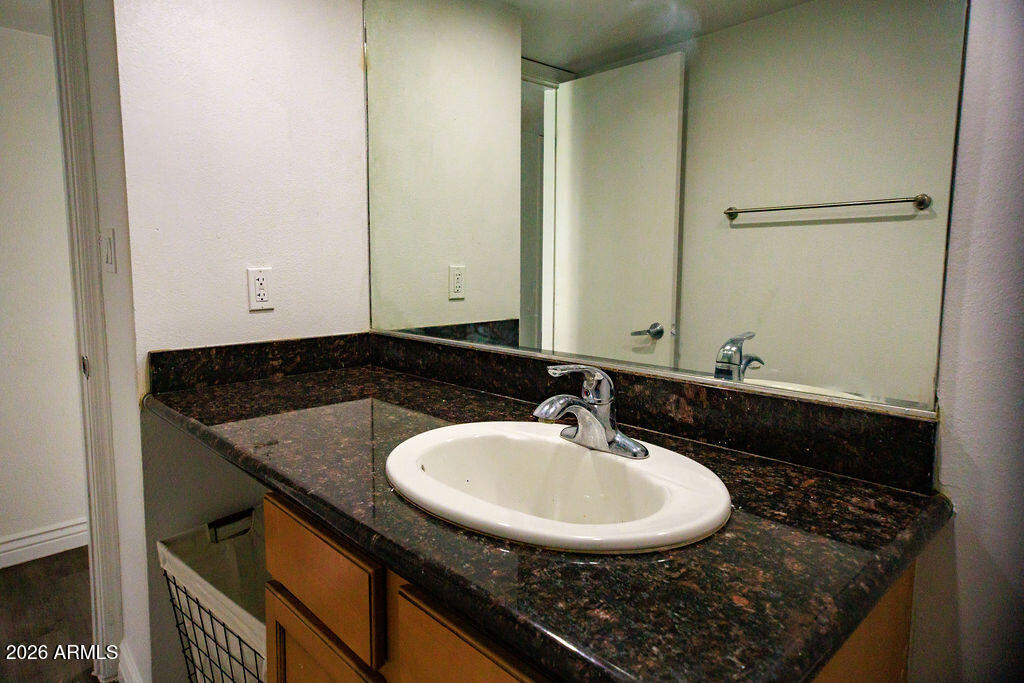 1702 West Tuckey Lane, Unit 103 Phoenix, AZ 85015 - Photo 12 of 13 a bathroom with a sink and a mirror