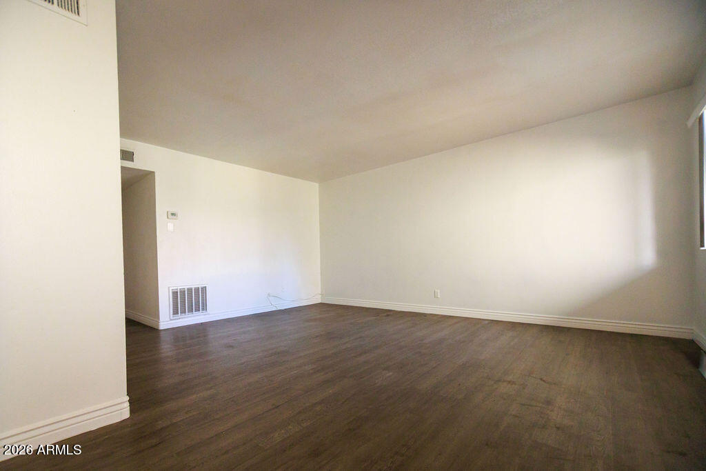 1702 West Tuckey Lane, Unit 103 Phoenix, AZ 85015 - Photo 5 of 13 an empty room with wooden floor