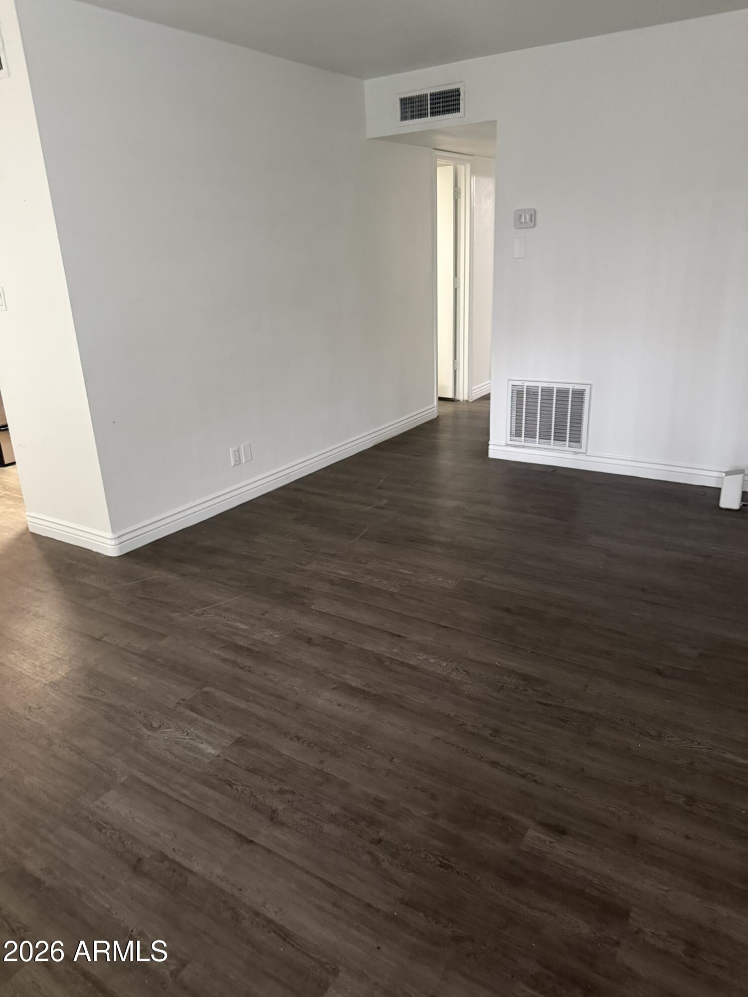 1702 West Tuckey Lane, Unit 103 Phoenix, AZ 85015 - Photo 6 of 13 an empty room with wooden floor and windows