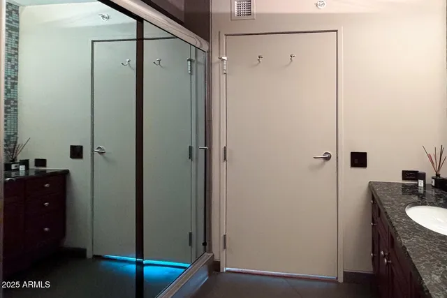 a bathroom with a granite countertop sink a mirror and shower