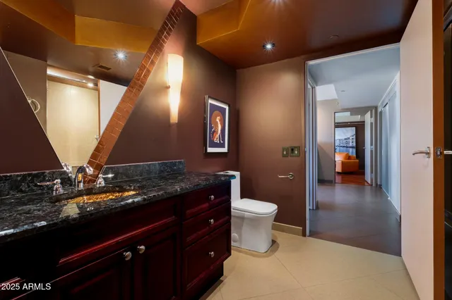 a bathroom with a granite countertop sink a toilet and a vanity