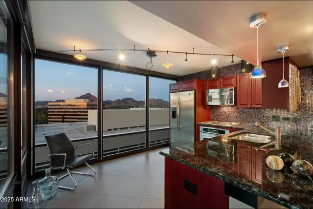 a kitchen with stainless steel appliances granite countertop a sink and a stove