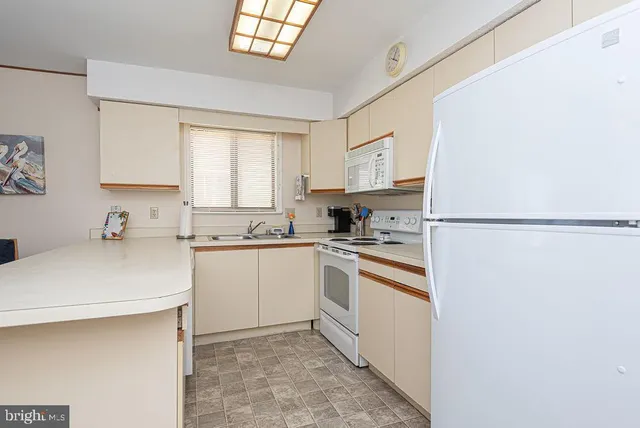 a kitchen with a sink a stove a refrigerator and cabinets