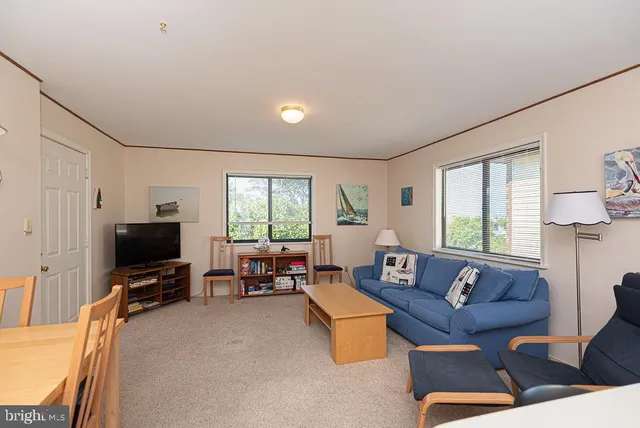 a living room with furniture a flat screen tv and a window