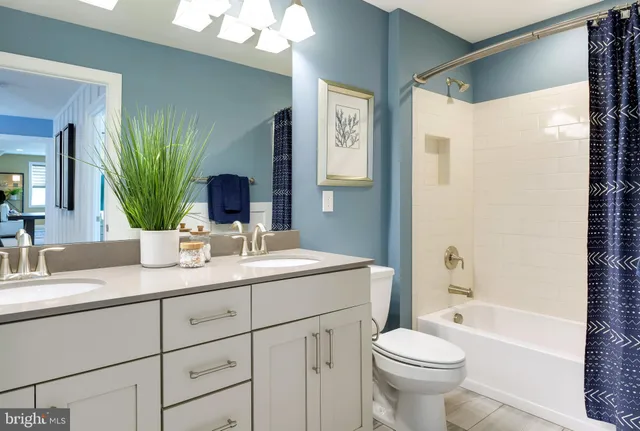 a bathroom with a double vanity sink toilet and shower