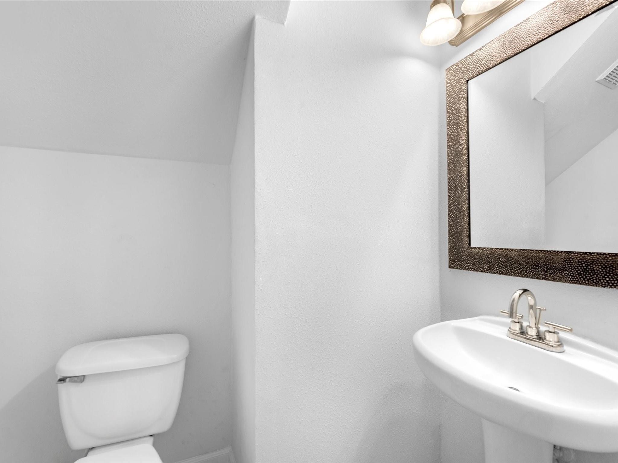 14306 Spring Marsh Court Cypress, TX 77429 - Photo 13 of 26 a bathroom with a toilet a sink and mirror