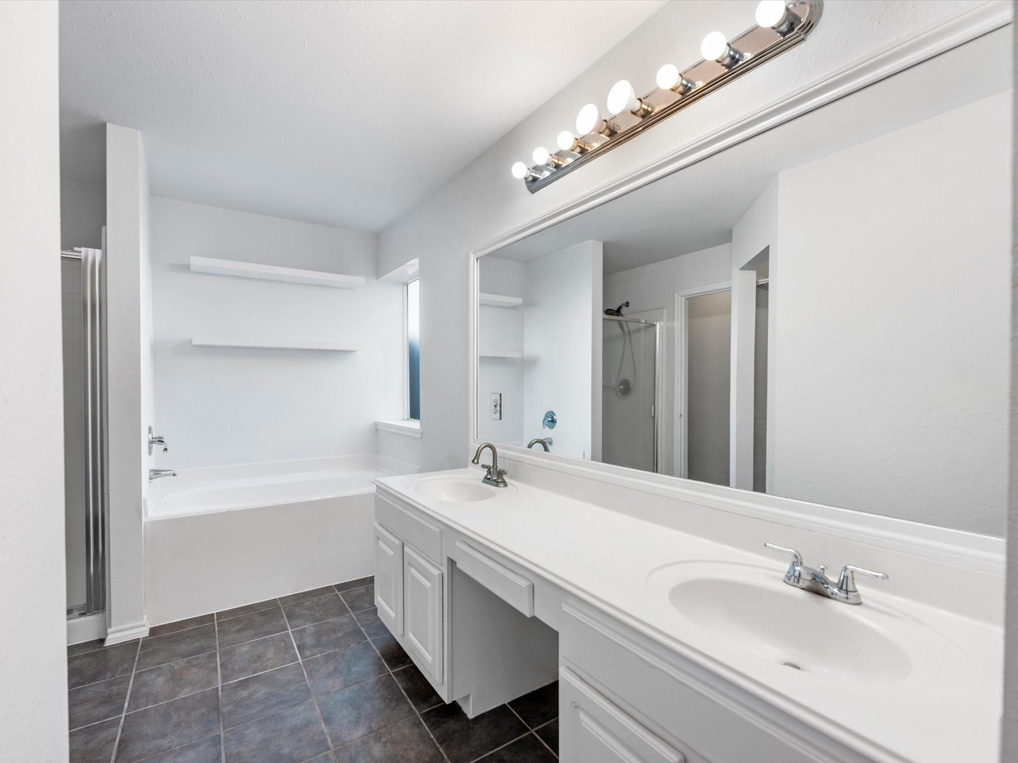 14306 Spring Marsh Court Cypress, TX 77429 - Photo 19 of 26 a bathroom with a bathtub a sink and a mirror
