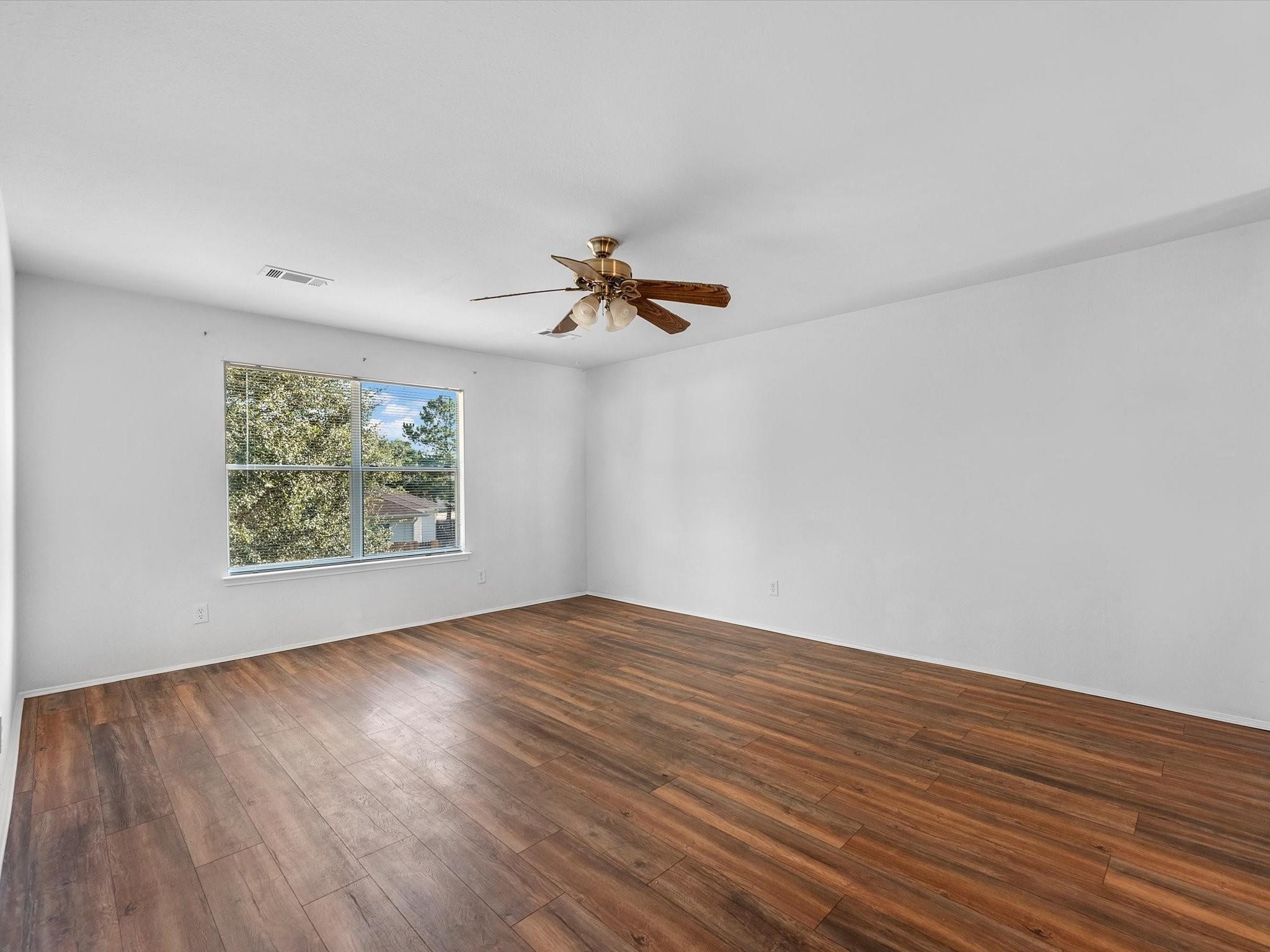 14306 Spring Marsh Court Cypress, TX 77429 - Photo 24 of 26 an empty room with wooden floor fan and windows