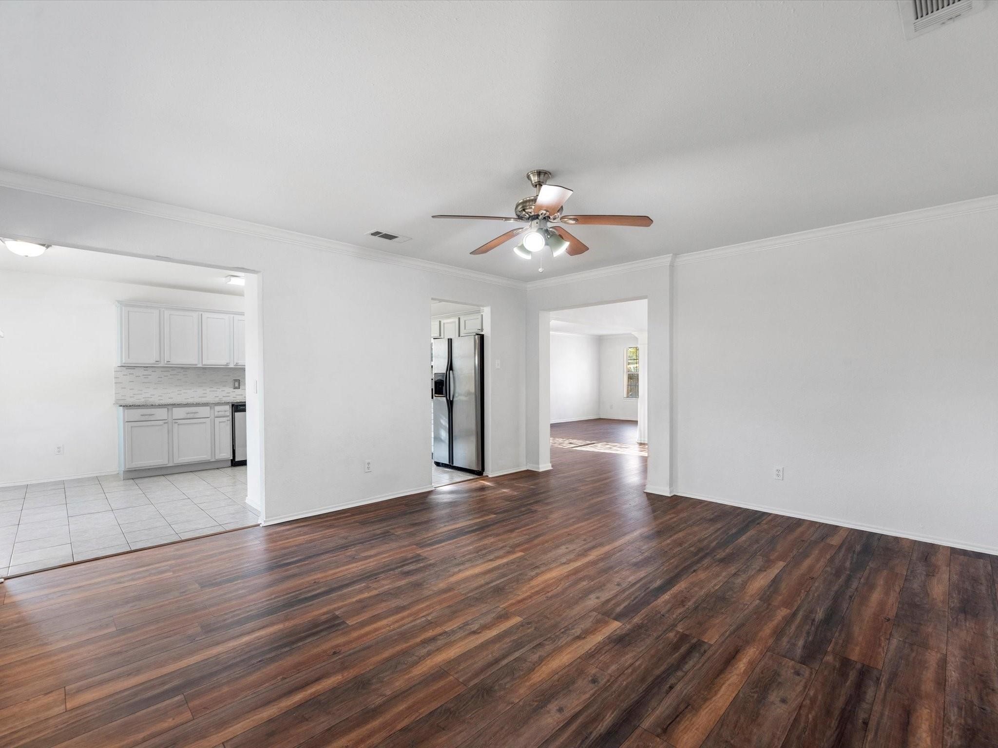 14306 Spring Marsh Court Cypress, TX 77429 - Photo 7 of 26 a view of an empty room with wooden floor and a kitchen