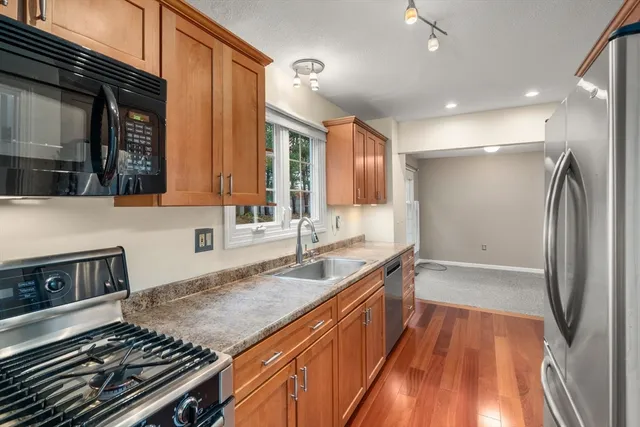 a kitchen with granite countertop a sink stove and refrigerator